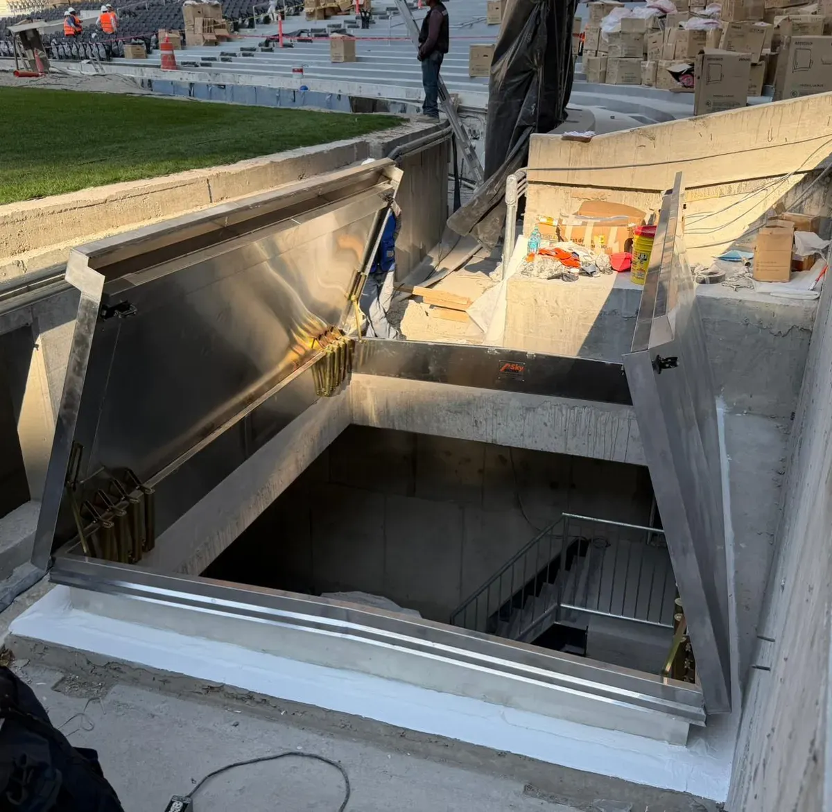 Escotilla doble hoja de gran formato instalada en estadio, para acceso de equipos a nivel piso